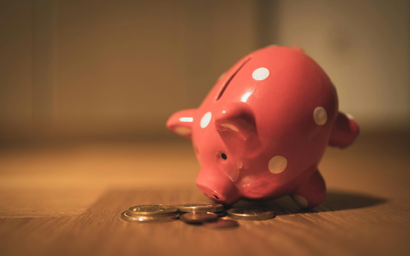 pink pig coin bank on brown wooden table by Andre Taissin courtesy of Unsplash.