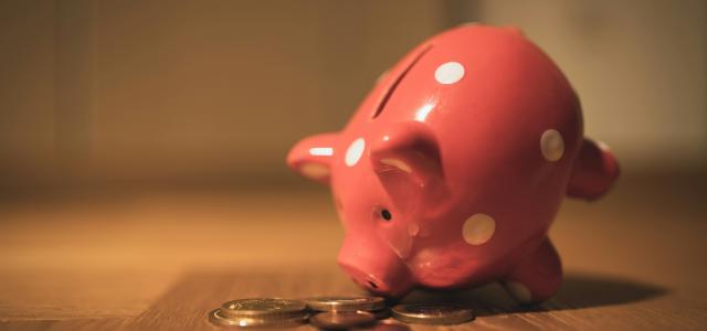 pink pig coin bank on brown wooden table by Andre Taissin courtesy of Unsplash.