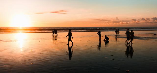 people at the beach during golden hour by George Bakos courtesy of Unsplash.